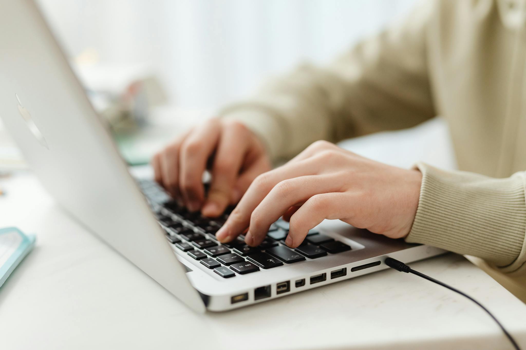 Close-up shot of hands typing on a laptop keyboard indoors, perfect for technology, business, and lifestyle themes.
